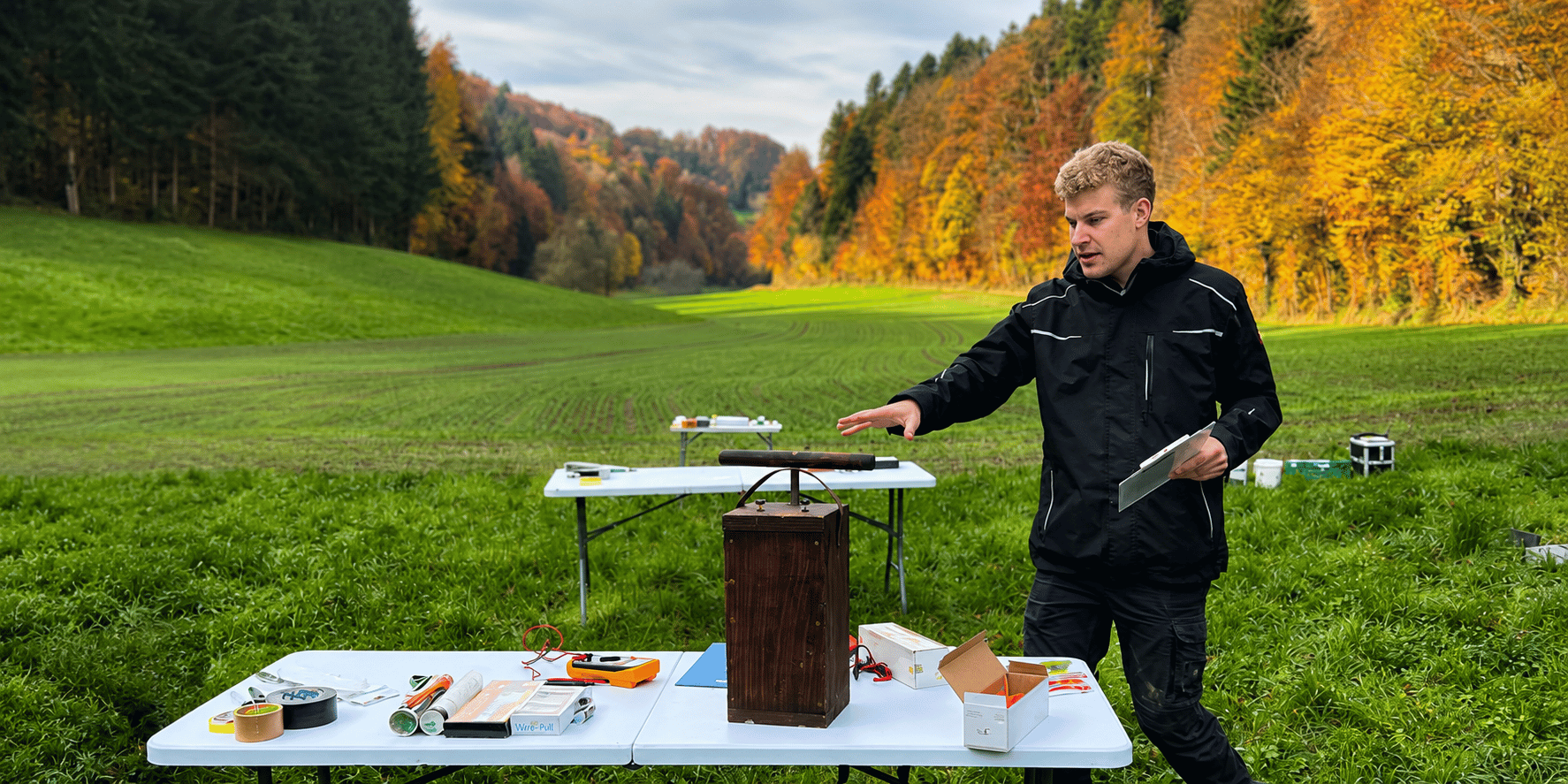 Janosch Bär erklärt bei einer praktischen Ausbildung im Freien den sicheren Umgang mit pyrotechnischer Technik und vermittelt Fachwissen für angehende Feuerwerker.