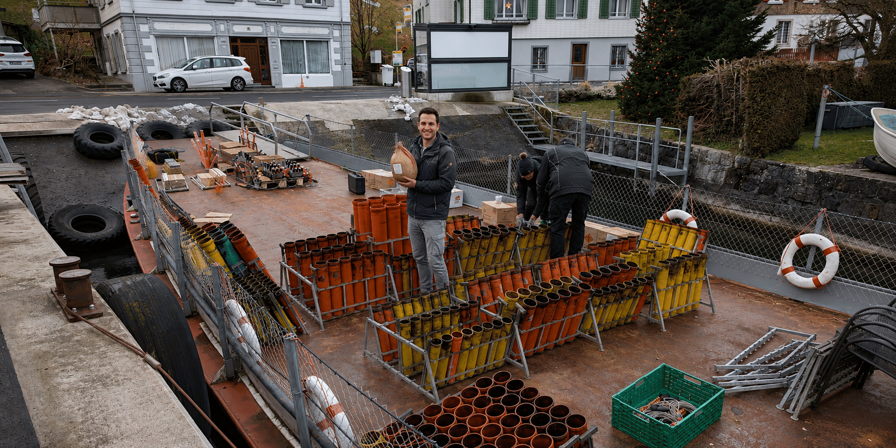 Mitglieder des Kamuro Feuerwerksvereins bereiten auf einem Ponton ein professionelles Seefeuerwerk vor und richten die Feuerwerksgestelle für eine sichere Durchführung aus.